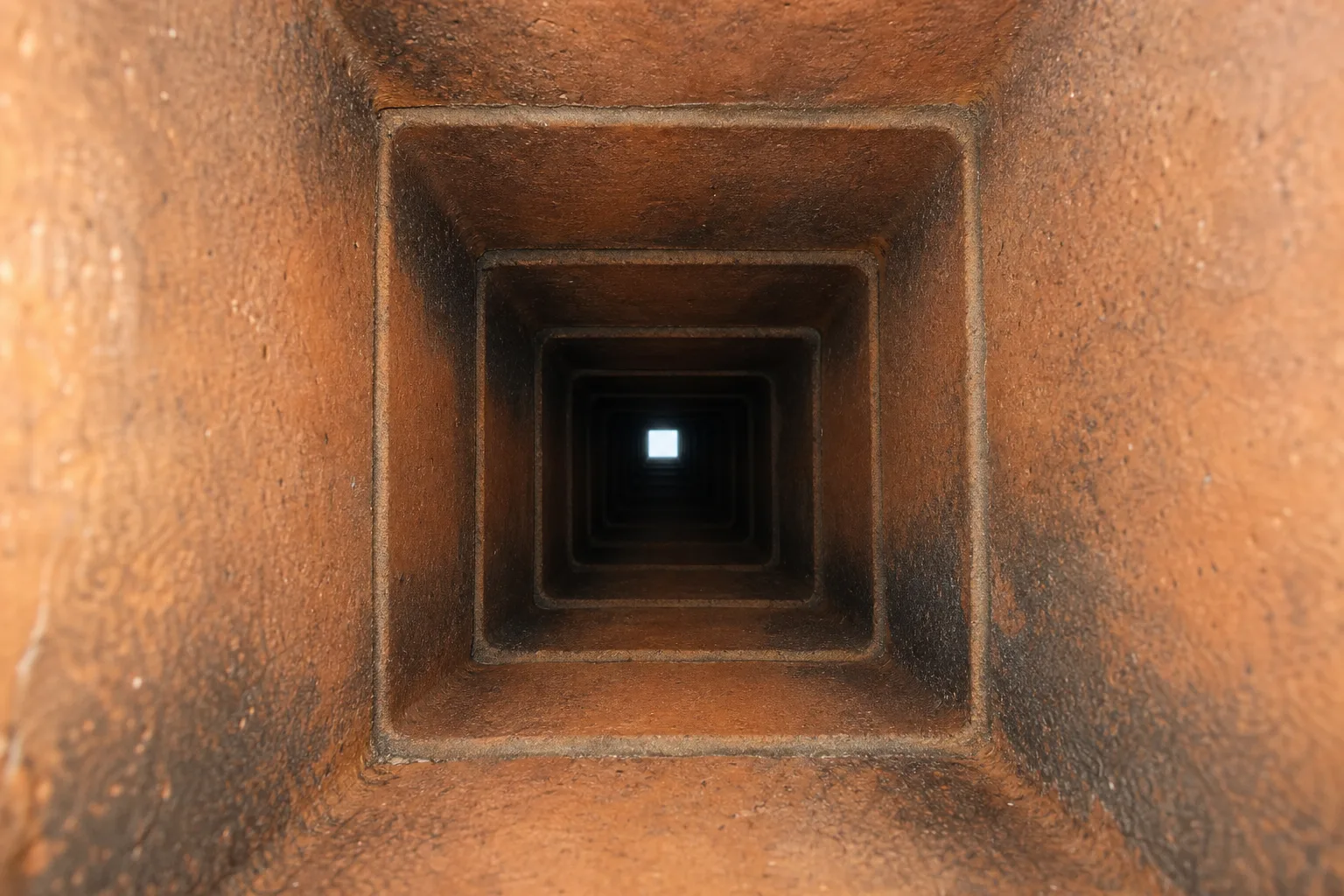 inside of a chimney showing sound square clay flue tile liner in typical good condition