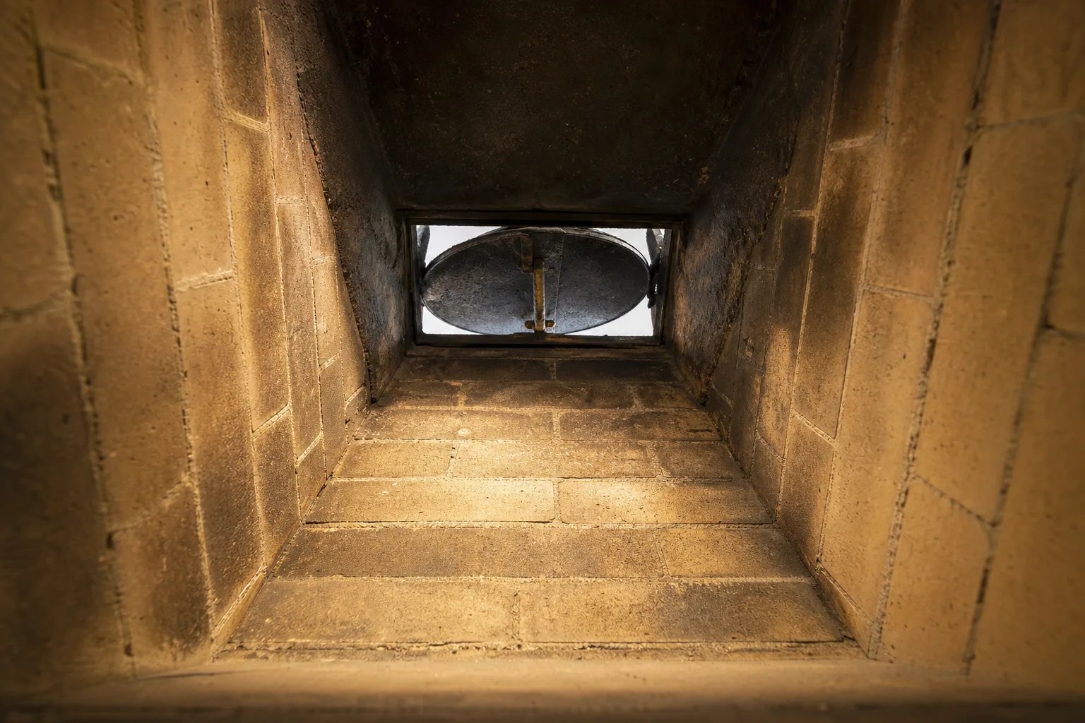 inside of a chimney seen looking up from the firebox toward the open damper and throat