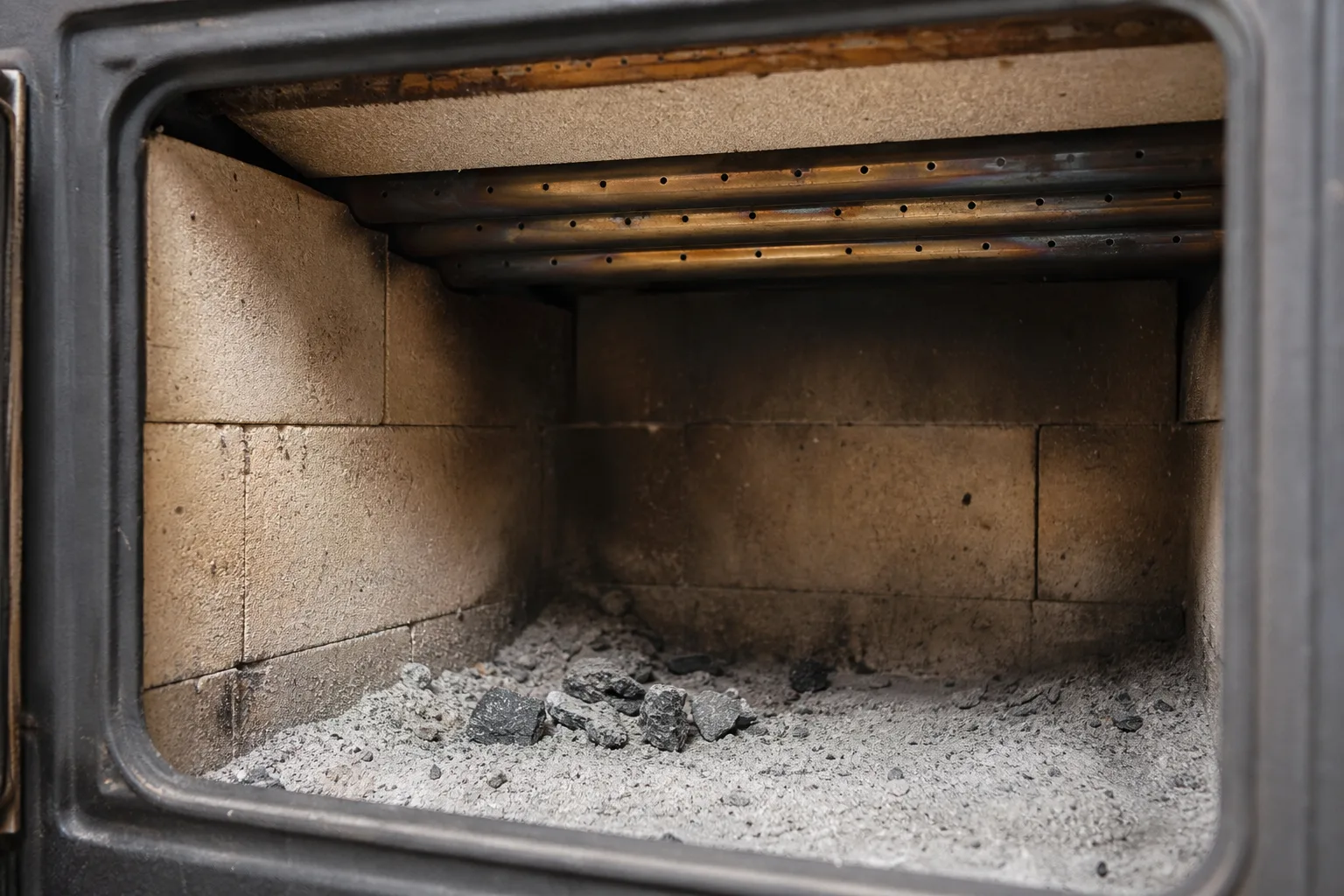 high efficiency wood stove firebox interior with stainless secondary air tubes and firebrick
