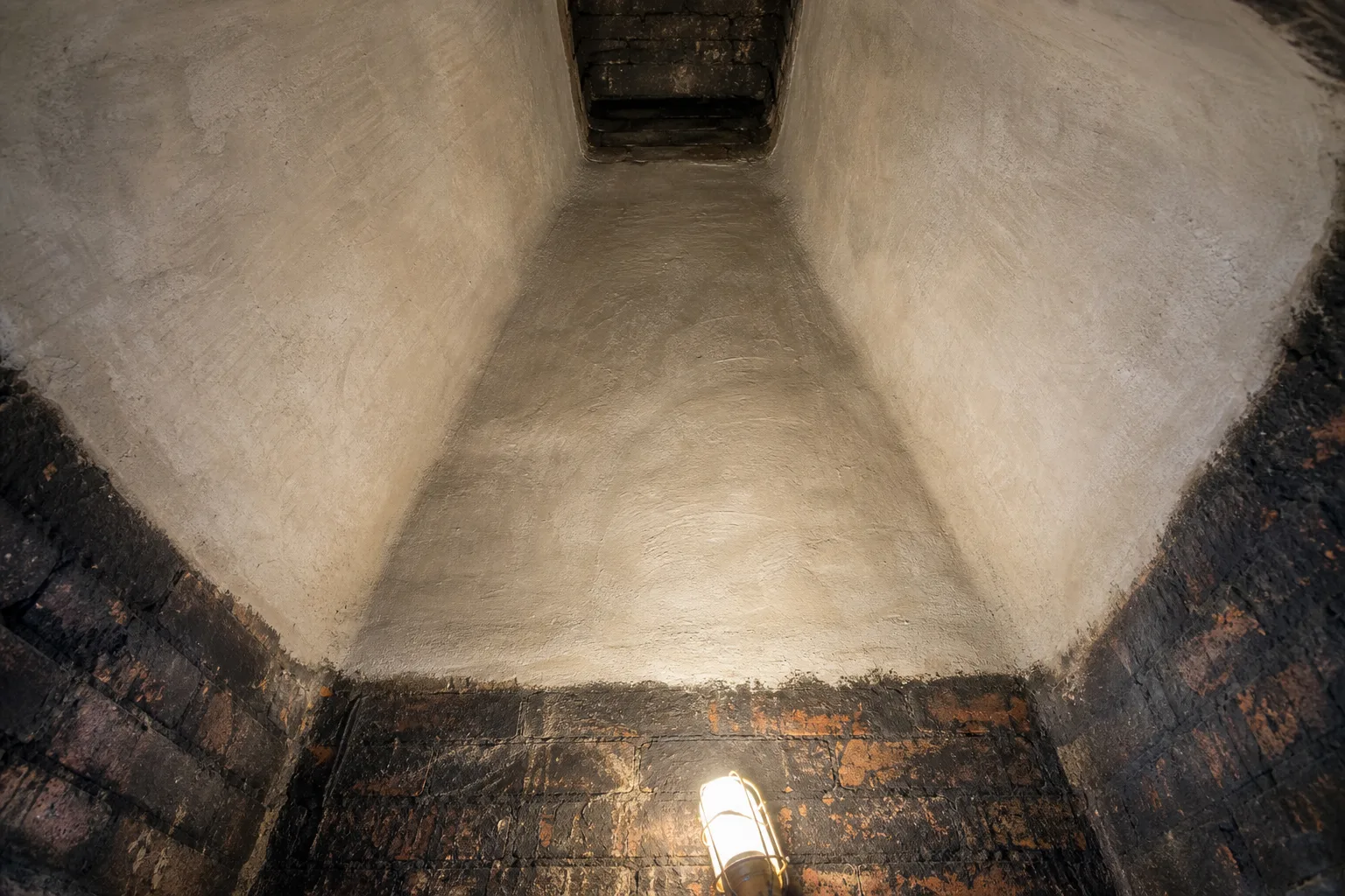 Smoke chamber parging after condition, the same chamber coated smooth in pale refractory mortar