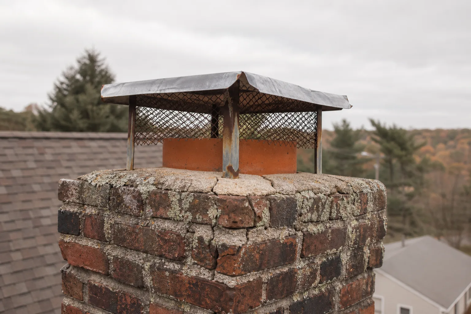 chimney inspection ct: cracked mortar crown, clay flue tile and a dented chimney cap