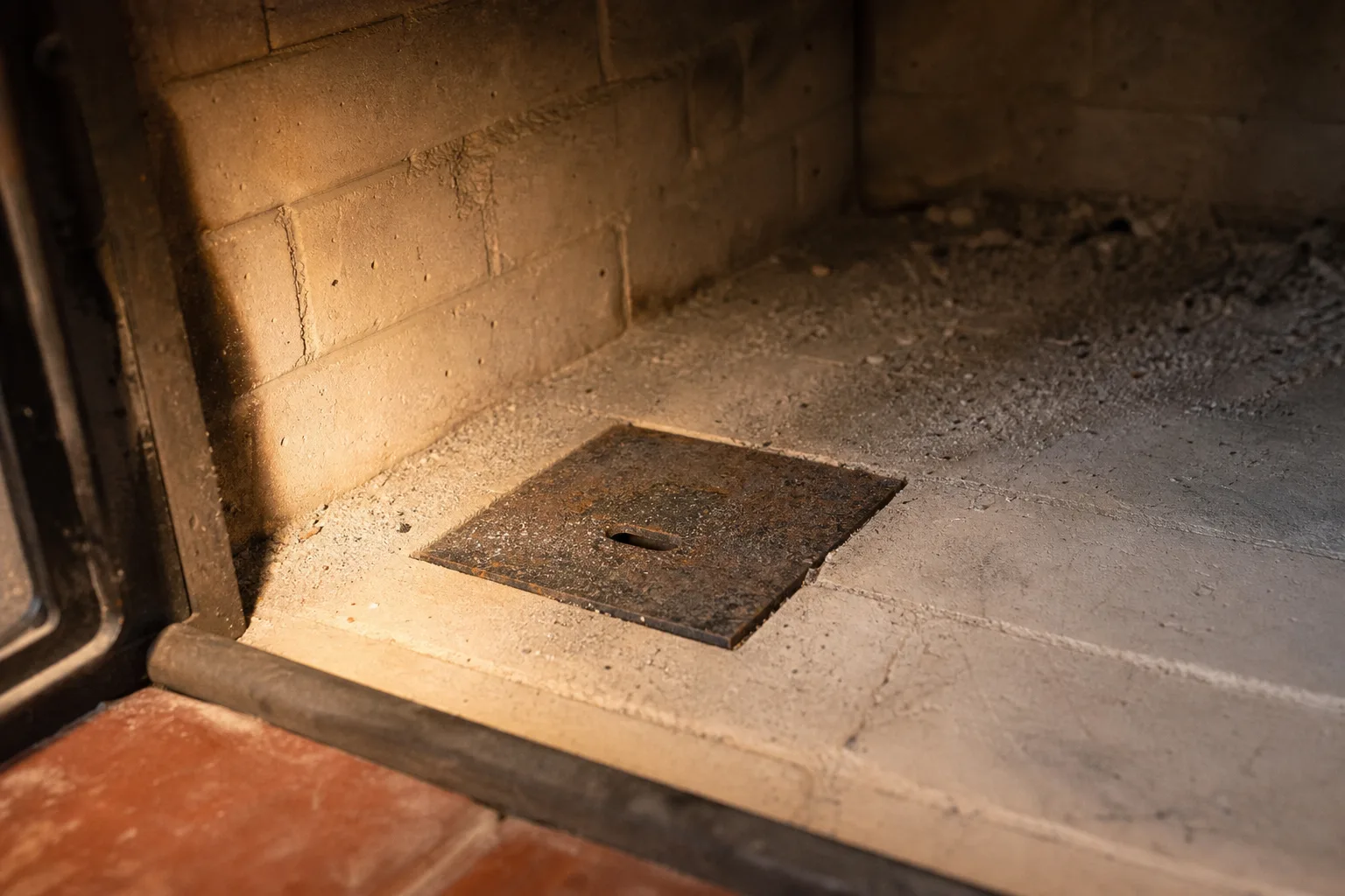 What is the bottom of a fireplace called when there is a metal door: cast-iron ash dump in the firebox floor