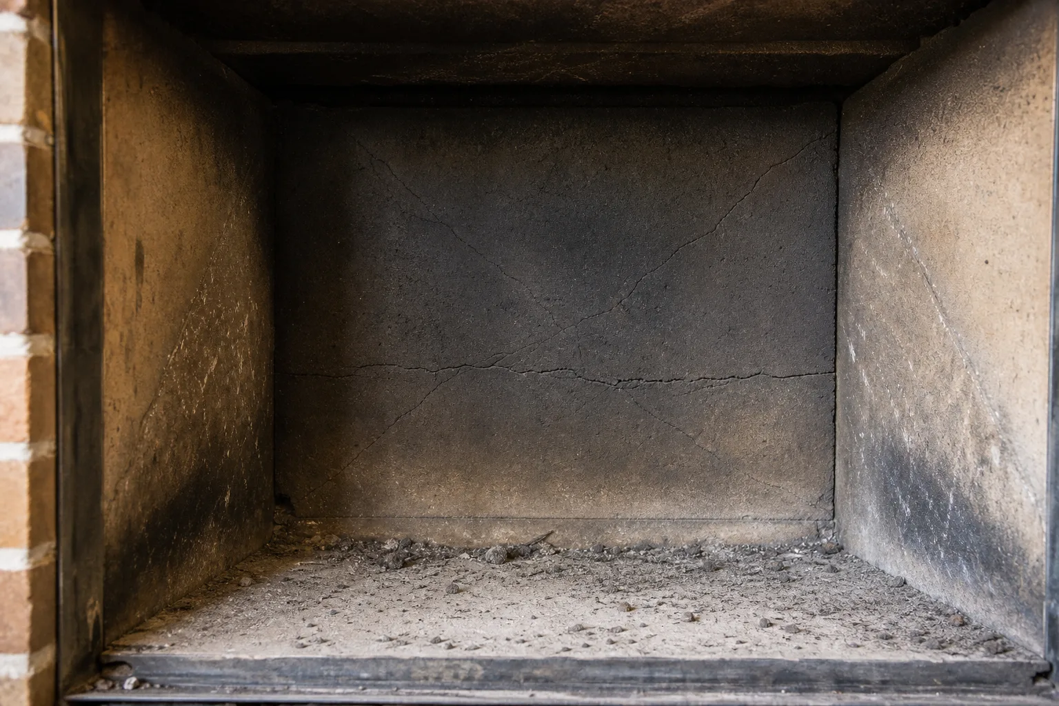 prefab fireplace refractory panel in typical worn condition with soot and hairline cracks