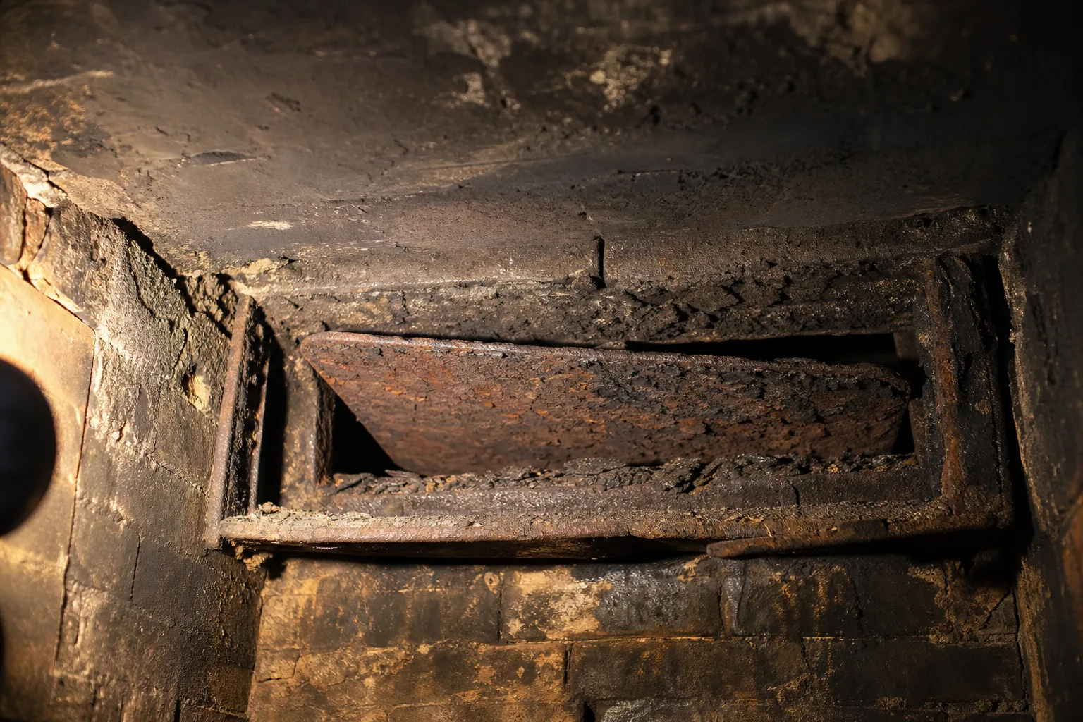 Chimney dampers in typical worn condition, a warped and rusted throat damper plate sitting askew in its frame