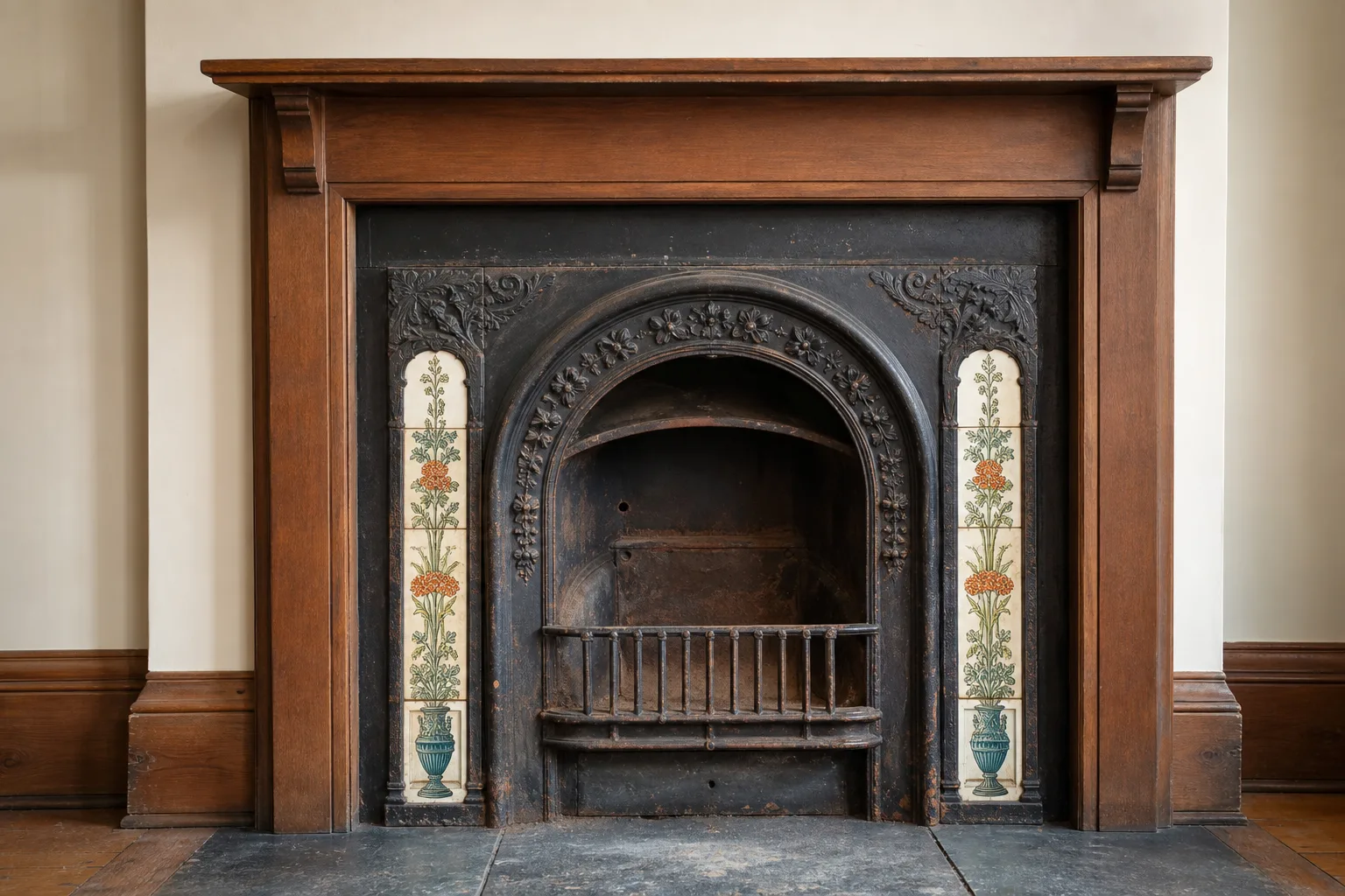 Cast iron fireplace insert of the Victorian antique type, ornate and unlit in a period fireplace opening