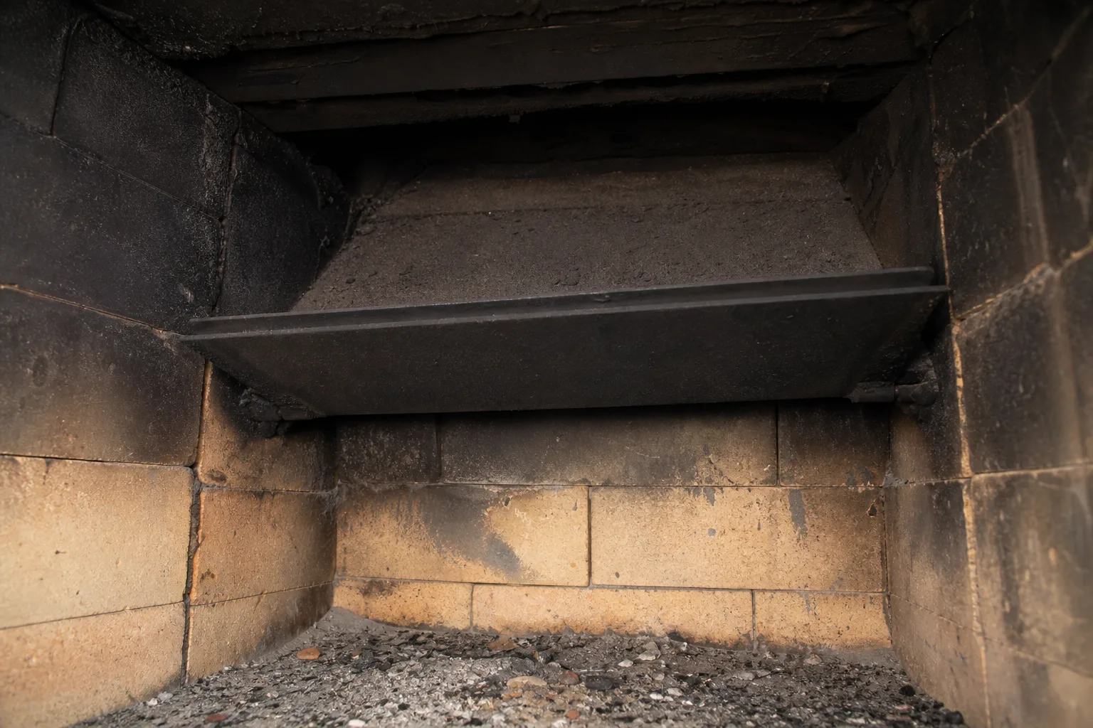 raccoon in chimney hiding spot, the smoke shelf ledge above an open fireplace damper